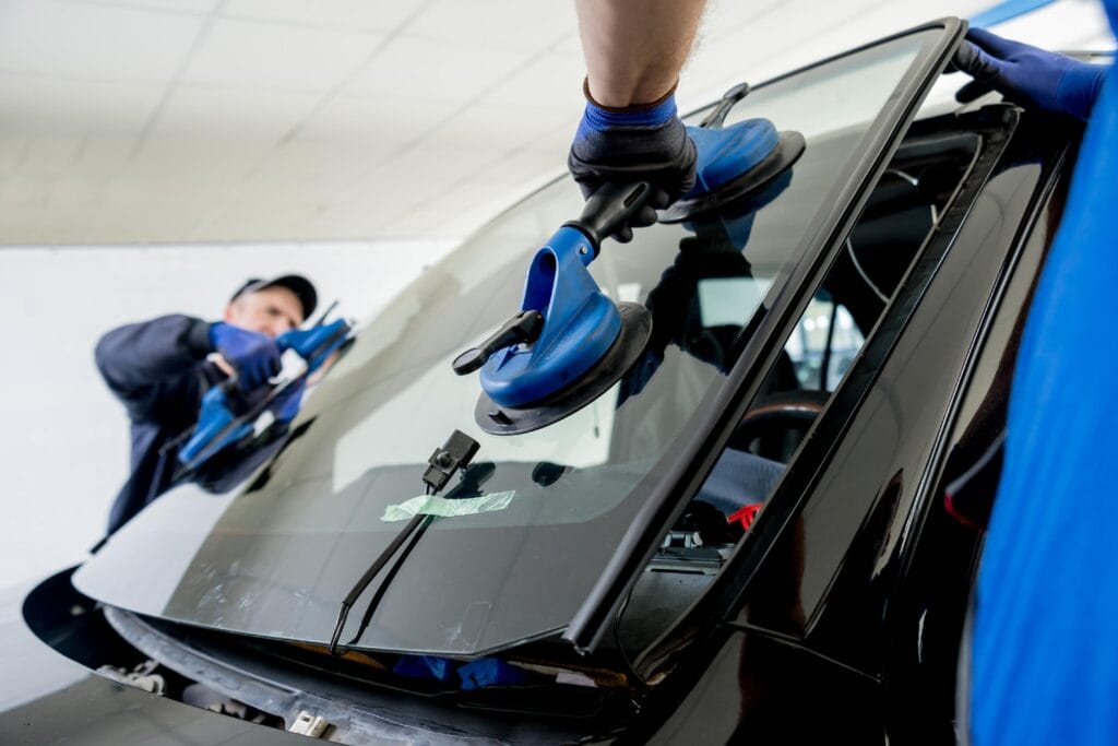 Auto Glass Shop workers replacing windshield